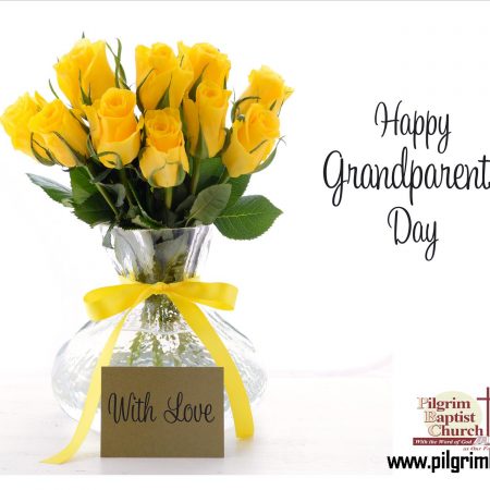 Grandparents Day words written and yellow roses in a glass vase.